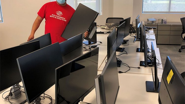 IT technician installing monitor screen in JLL office workplace